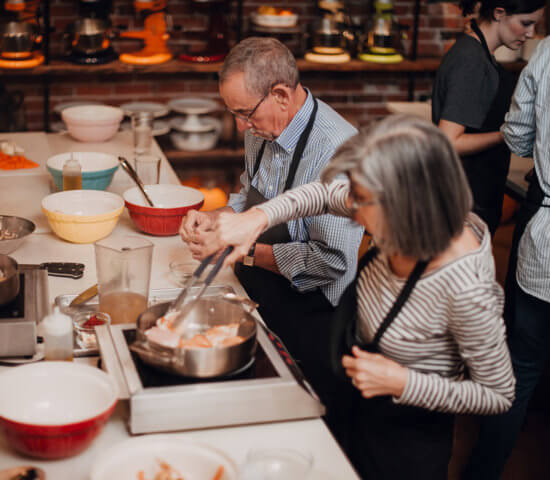 Couple Enjoying a cooking class at the Teaching Kitchen at Ginger and Baker