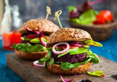 Veggie beet and quinoa burger with avocado on the vintage wooden board