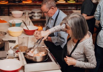 Couple Enjoying a cooking class at the Teaching Kitchen at Ginger and Baker