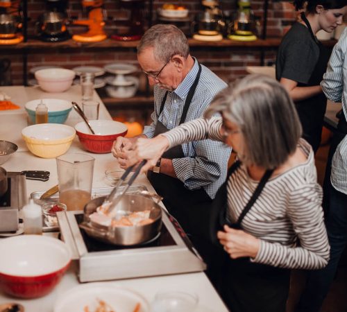 Couple Enjoying a cooking class at the Teaching Kitchen at Ginger and Baker